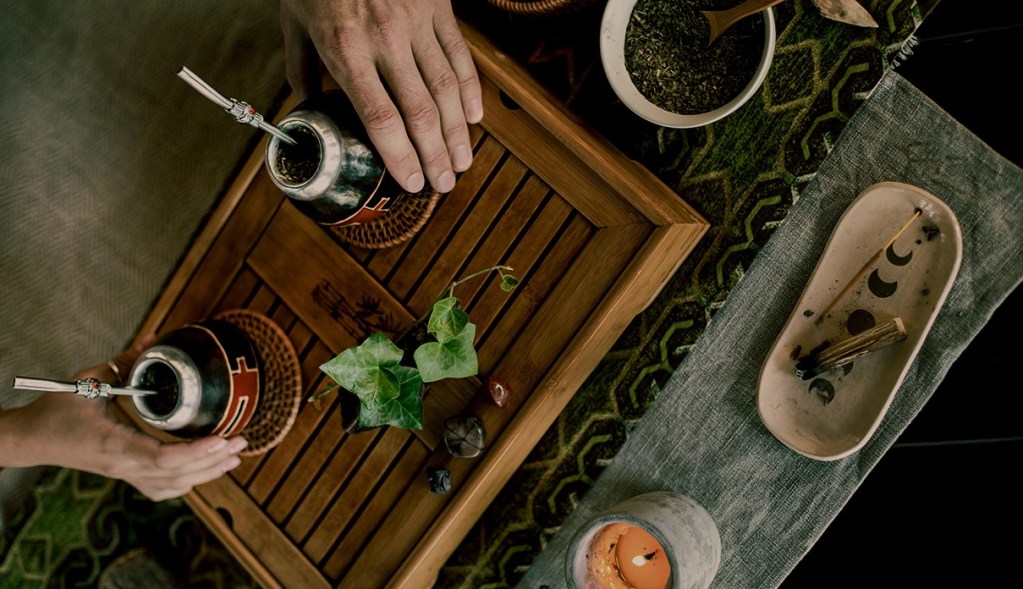 Preparación de una infusión tradicional sobre una bandeja de madera de bambú con incienso encendido, representando el bienestar y el slow travel en Asia.